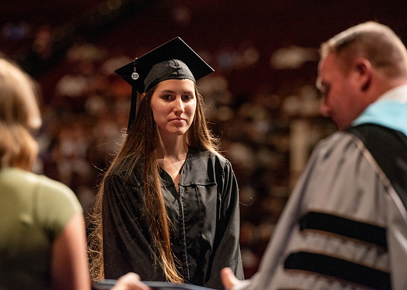 Students partipate in walking to graduate from the College of Business and Communication.
