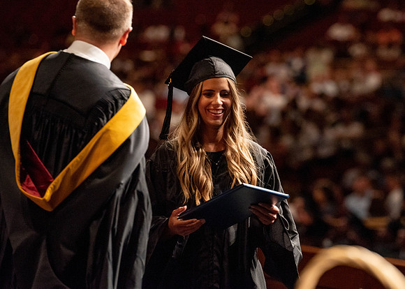 Students partipate in walking to graduate from the College of Business and Communication.