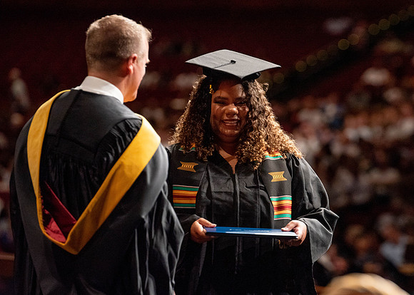 Students partipate in walking to graduate from the College of Business and Communication.