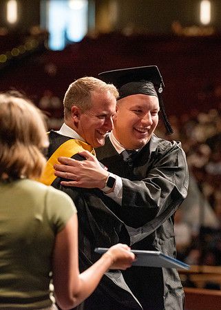 Students partipate in walking to graduate from the College of Business and Communication.