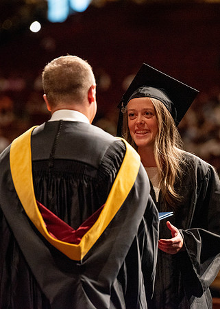 Students partipate in walking to graduate from the College of Business and Communication.