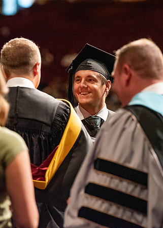 Students partipate in walking to graduate from the College of Business and Communication.