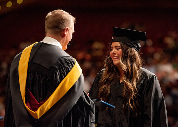 Students partipate in walking to graduate from the College of Business and Communication.