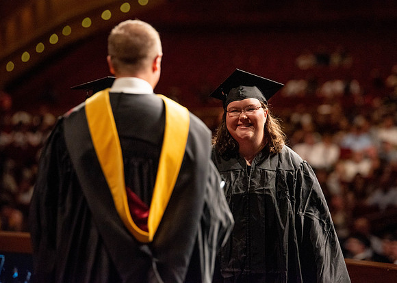 Students partipate in walking to graduate from the College of Business and Communication.