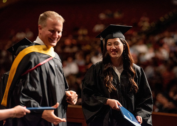 Students partipate in walking to graduate from the College of Business and Communication.