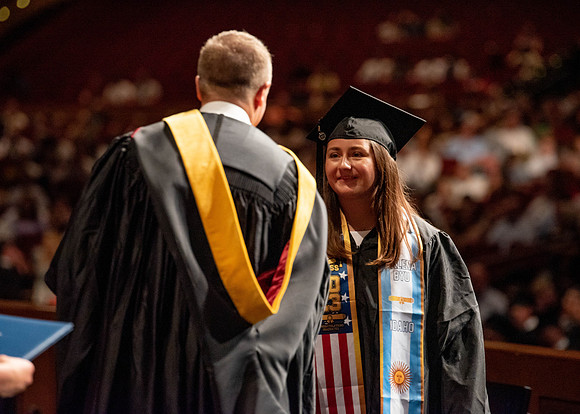 Students partipate in walking to graduate from the College of Business and Communication.