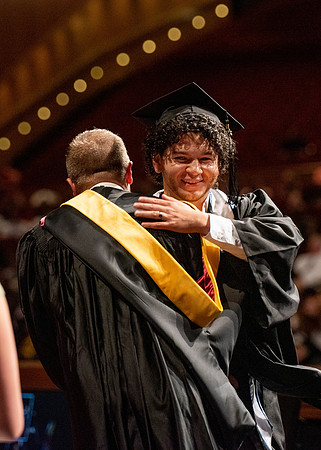 Students partipate in walking to graduate from the College of Business and Communication.