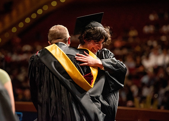 Students partipate in walking to graduate from the College of Business and Communication.