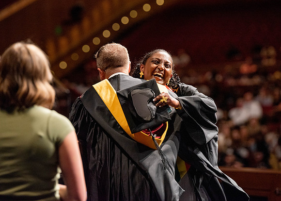Students partipate in walking to graduate from the College of Business and Communication.