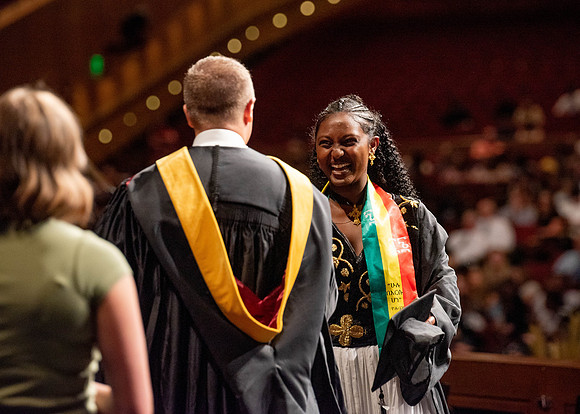 Students partipate in walking to graduate from the College of Business and Communication.