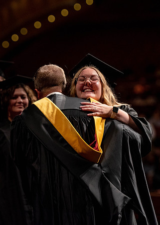 Students partipate in walking to graduate from the College of Business and Communication.