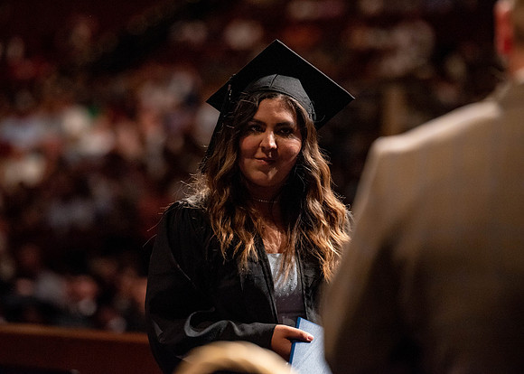 Students partipate in walking to graduate from the College of Business and Communication.