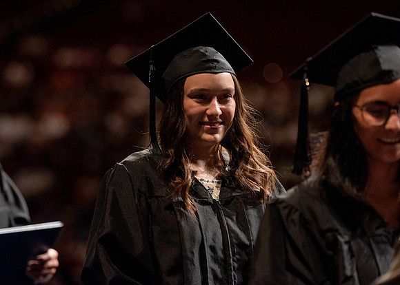 Students partipate in walking to graduate from the College of Business and Communication.