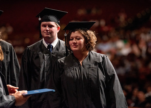 Students partipate in walking to graduate from the College of Business and Communication.