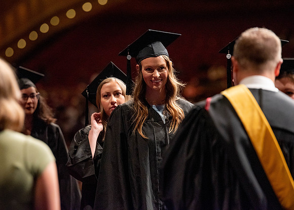 Students partipate in walking to graduate from the College of Business and Communication.