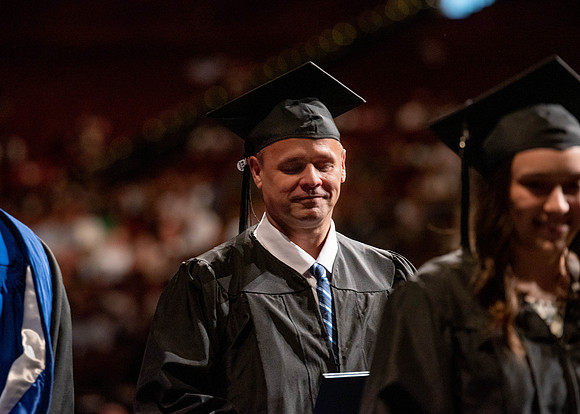 Students partipate in walking to graduate from the College of Business and Communication.