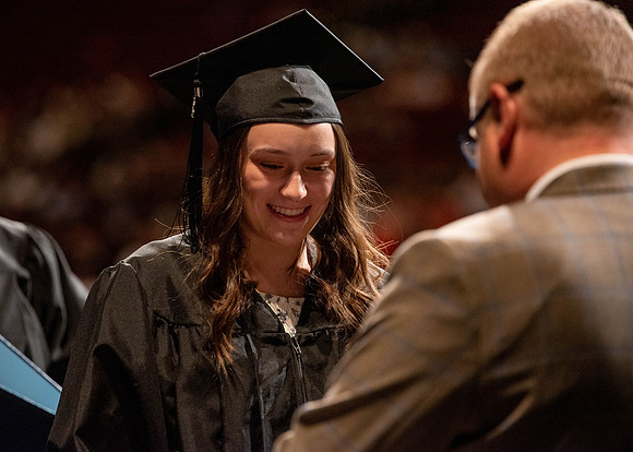 Students partipate in walking to graduate from the College of Business and Communication.