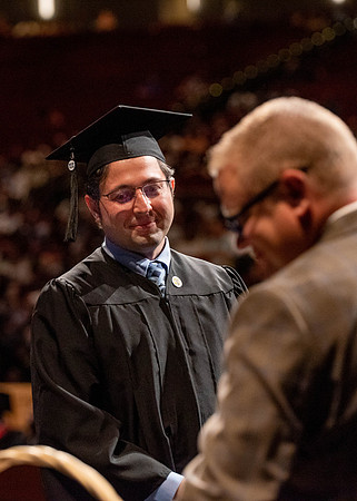 Students partipate in walking to graduate from the College of Business and Communication.