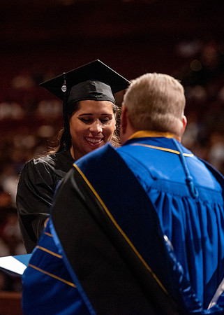 Students partipate in walking to graduate from the College of Business and Communication.