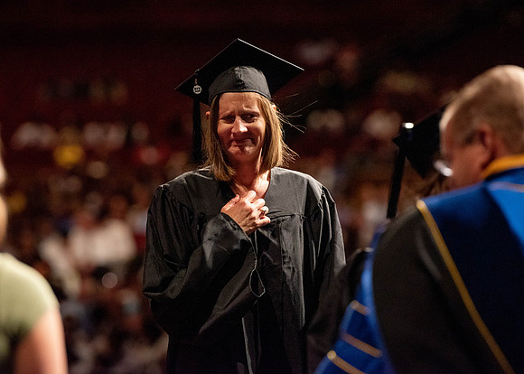 Students partipate in walking to graduate from the College of Business and Communication.