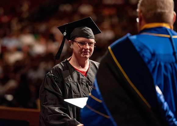 Students partipate in walking to graduate from the College of Business and Communication.