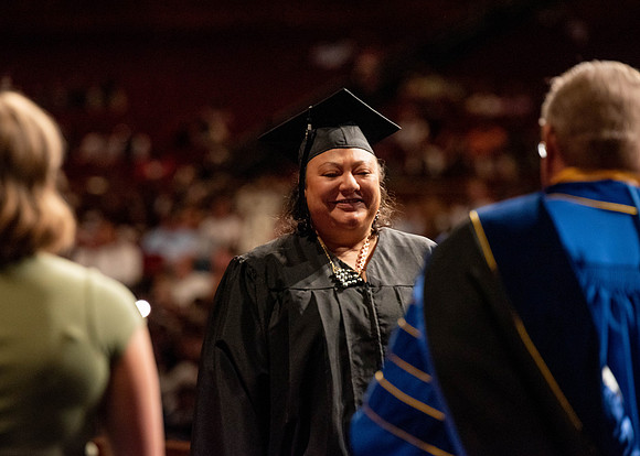 Students partipate in walking to graduate from the College of Business and Communication.