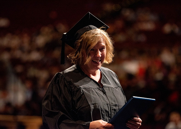 Students partipate in walking to graduate from the College of Business and Communication.
