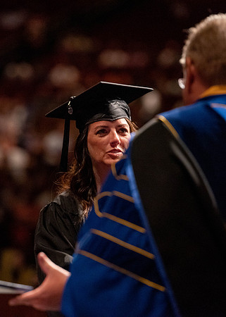 Students partipate in walking to graduate from the College of Business and Communication.