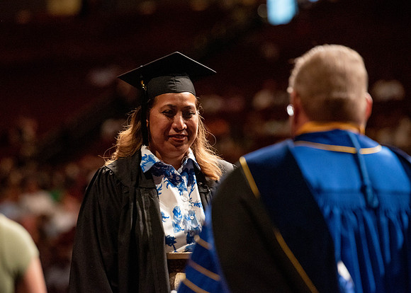 Students partipate in walking to graduate from the College of Business and Communication.