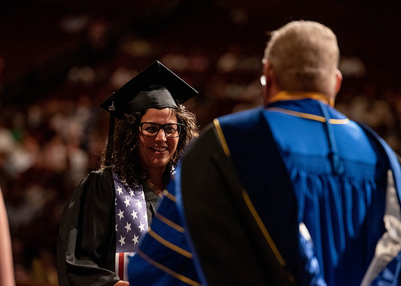 Students partipate in walking to graduate from the College of Business and Communication.