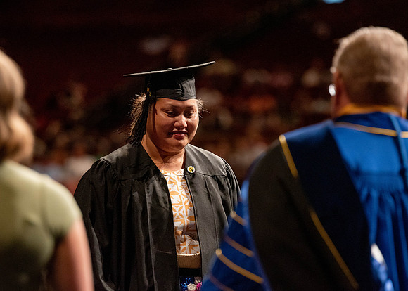 Students partipate in walking to graduate from the College of Business and Communication.