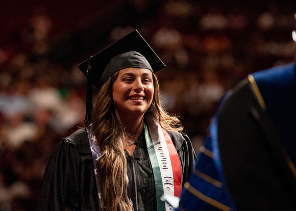 Students partipate in walking to graduate from the College of Business and Communication.