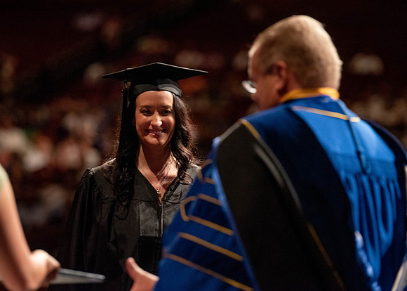 Students partipate in walking to graduate from the College of Business and Communication.