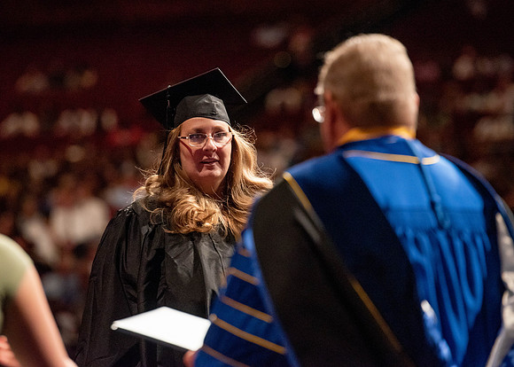 Students partipate in walking to graduate from the College of Business and Communication.