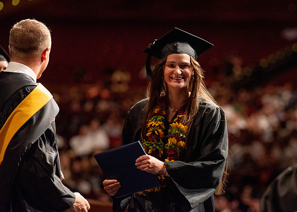 Students partipate in walking to graduate from the College of Business and Communication.