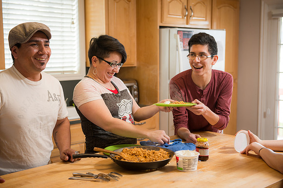 Pathway student, Marcela Avila in her home with her husband and three kids.