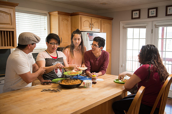 Pathway student, Marcela Avila in her home with her husband and three kids.