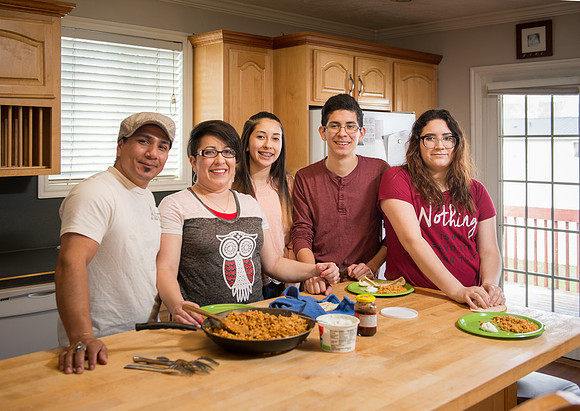 Pathway student, Marcela Avila in her home with her husband and three kids.