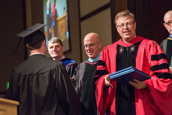 President Gilbert and Elder L. Whitney Clayton at graduation. April 2017