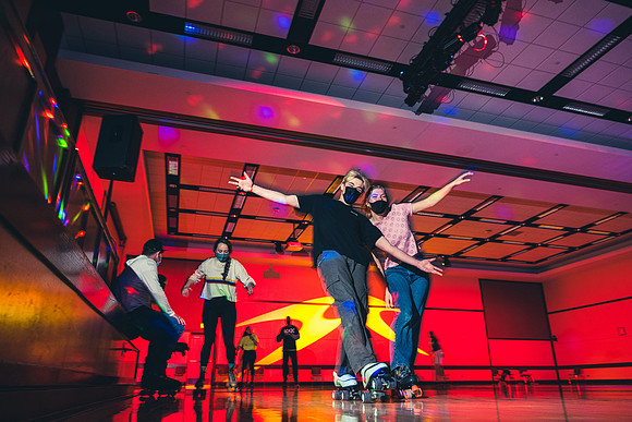 Students enjoy rollerskating a the MC wearing masks.