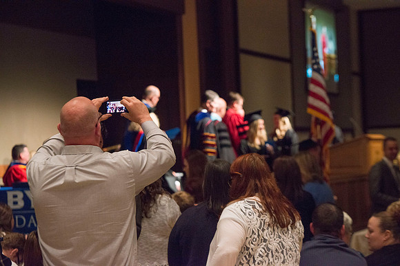 College of Language and Letters Convocation in the Manwaring Center Ballroom. Eric Walz, Pres Gilbert and Elder Clayton present the graduates with their diploma covers.