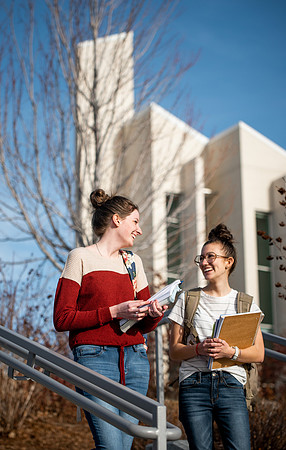 BYUI students Kira Wood and Abby Anderson walk around campus in front of the Taylor Building.