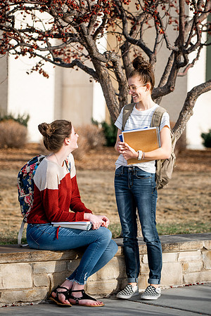 BYUI students Kira Wood and Abby Anderson walk around campus in front of the Taylor Building.