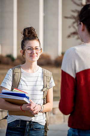 BYUI students Kira Wood and Abby Anderson walk around campus in front of the Taylor Building.