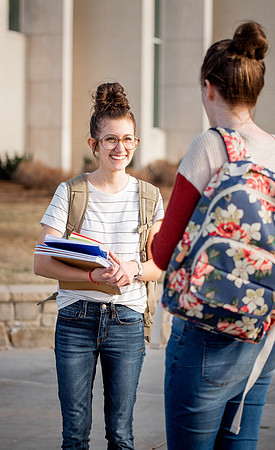 BYUI students Kira Wood and Abby Anderson walk around campus in front of the Taylor Building.