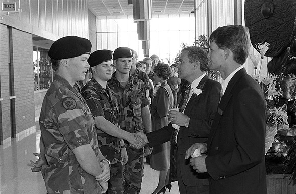 1989, President Steven D. Bennion, President of Ricks College greets students in the foyer of the Hart Building.