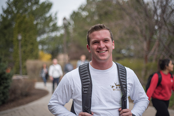 A student stands on campus in the Gardens. 2017
