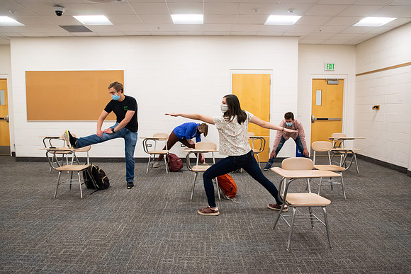 Examples of students staying safe and healthy during the COVID-19 pandemic by social distancing, following pathway arrows, and wearing face masks.
