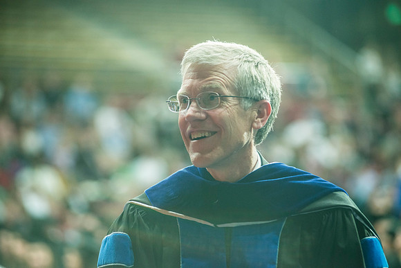 Elder W. Craig Swick and President Kim B. Clark award diploma covers to graduates in the College of Business and Communication.