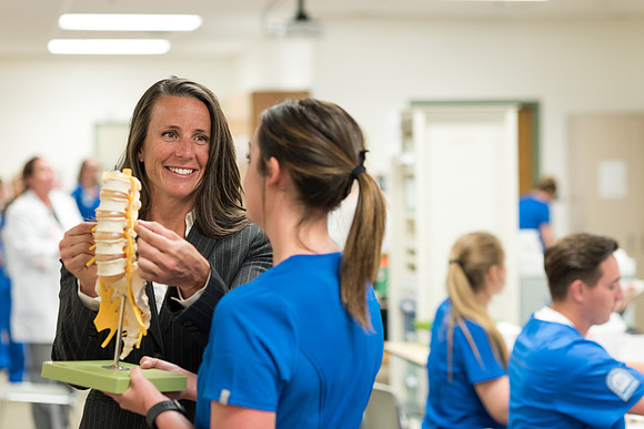 Erin Bennion helps students in a nursing lab. 2017